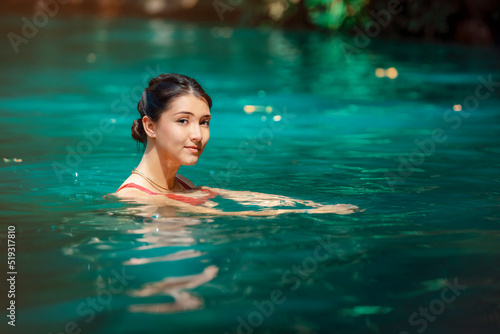 young Latina woman standing in blue green waters of Rio Blanco in Costa Rica