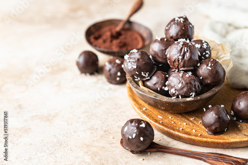 Vegan chickpea and peanut butter candies in chocolate glaze sprinkled with coconut chips. Energy balls. Healthy raw dessert without sugar.