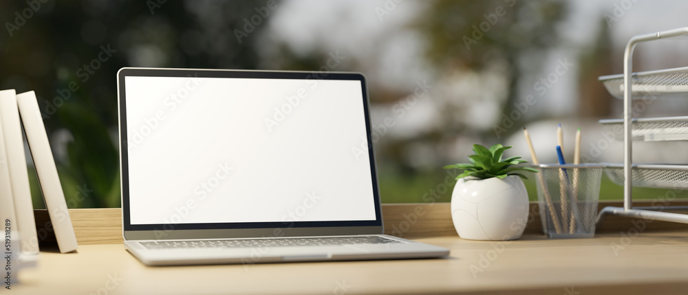 Fototapeta premium Office working desk with laptop computer white screen mockup and office supplies.