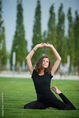 Girl doing yoga school age in sports form shows the elements of sports and asanas. © Fotoproff