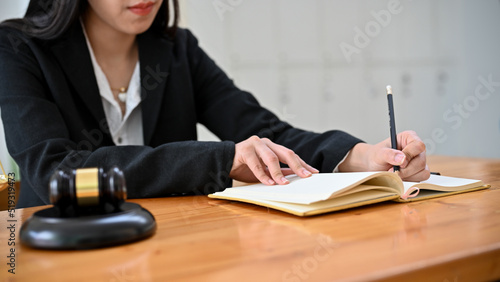 Professional Asian female lawyer working at her office desk, writing a notice or Resignation letter photo