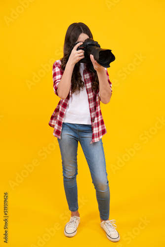 Teenager girl photographer with a dslr camera. Kid use digital camera. Child photographing. School of photography. Kid photographer beginner.