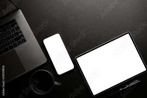 Obraz na plátně Stylish black office desk workspace top view, with smartphone and tablet mockup