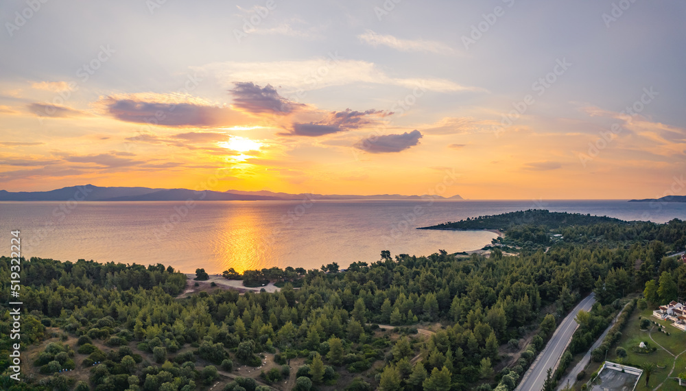 Natural beauty of Greek pine forest and famous Glarokavos beach and port seen from aerial perspective at sunset. Summer holidays concept. High quality photo