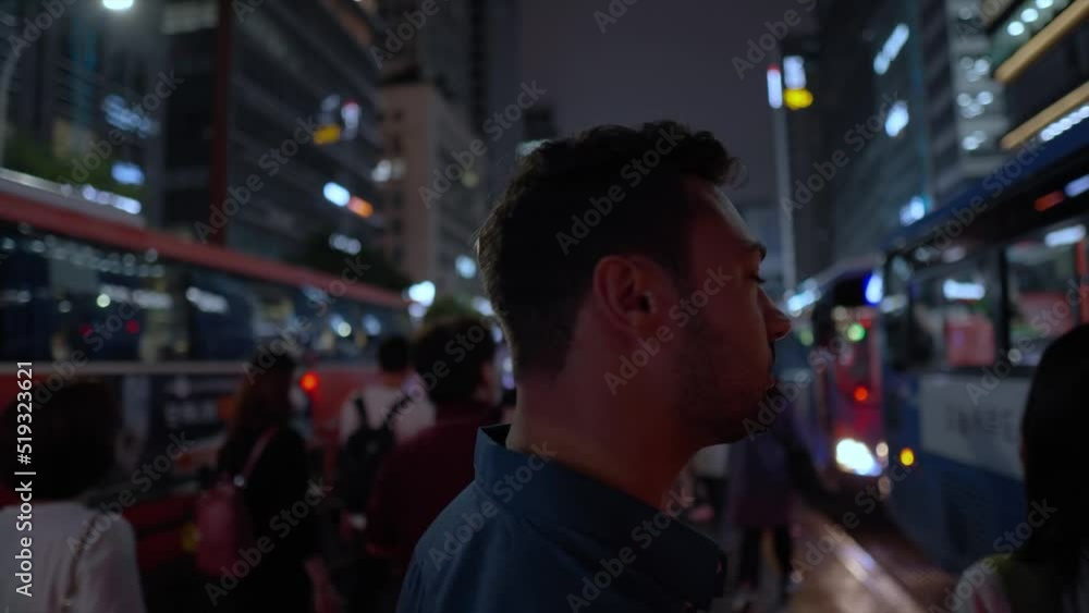 People take buses at night. Face closeup of young man surrounded with passing by commuting crowd of people in busy Seoul center at Gangnam station bus stop People take buses at night. Face closeup of young man surrounded with passing by commuting crowd of people in busy Seoul center at Gangnam station bus stop