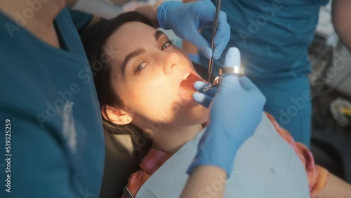 Female dentist with cartridge syringe injecting anesthetic medicine before teeth treatment photo