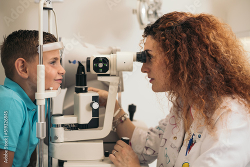 examination of a child with a slit lamp, microscope and focused light source. device for high-precision examination of the eye to determine the condition of the lens, the cornea.  photo