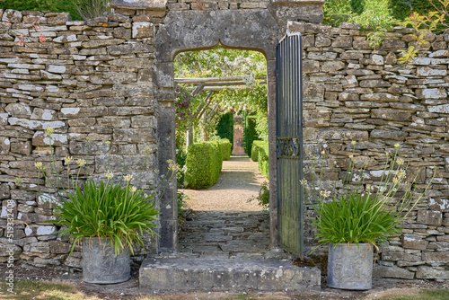 Entrance way to a large garden through a Cotswoild stone wall