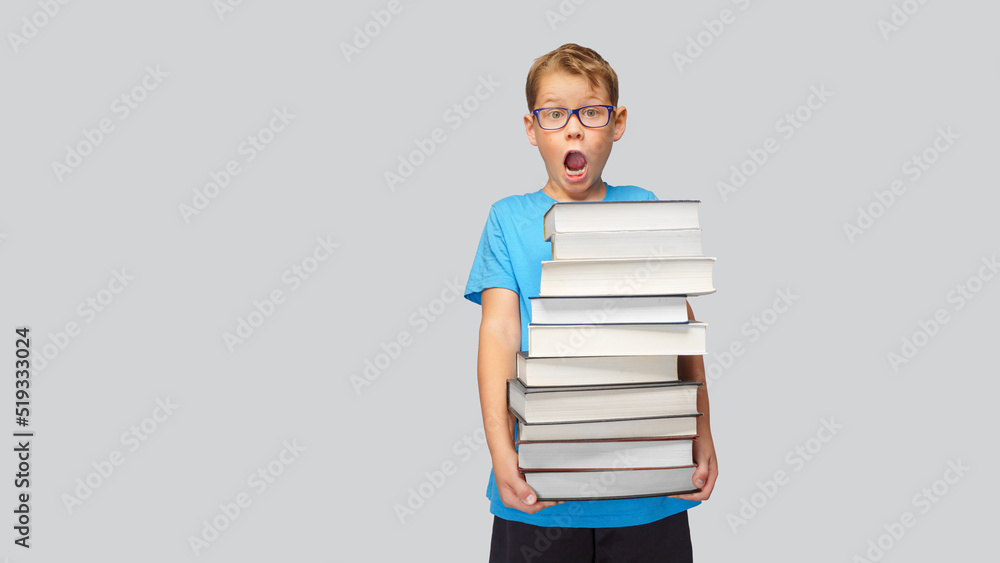 Boy carries a high stack of books - A lot of study material at school. Boy carries a high stack of books - A lot of study material at school.
