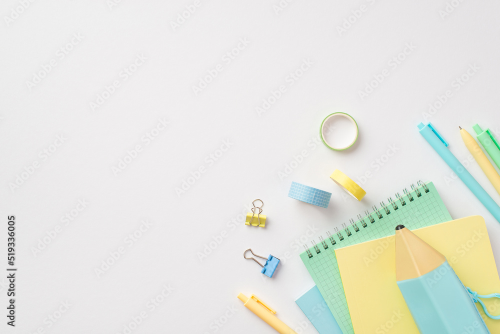 Back to school concept. Top view photo of school accessories pencil-case notepads pens binder clips and adhesive tape on isolated white background with copyspace Back to school concept. Top view photo of school accessories pencil-case notepads pens binder clips and adhesive tape on isolated white background with copyspace