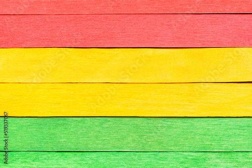 Colorful texture of wooden planks in traffic light colors. Wooden boards are arranged horizontally and painted in red, yellow and green. Wooden detailed background in three colors.