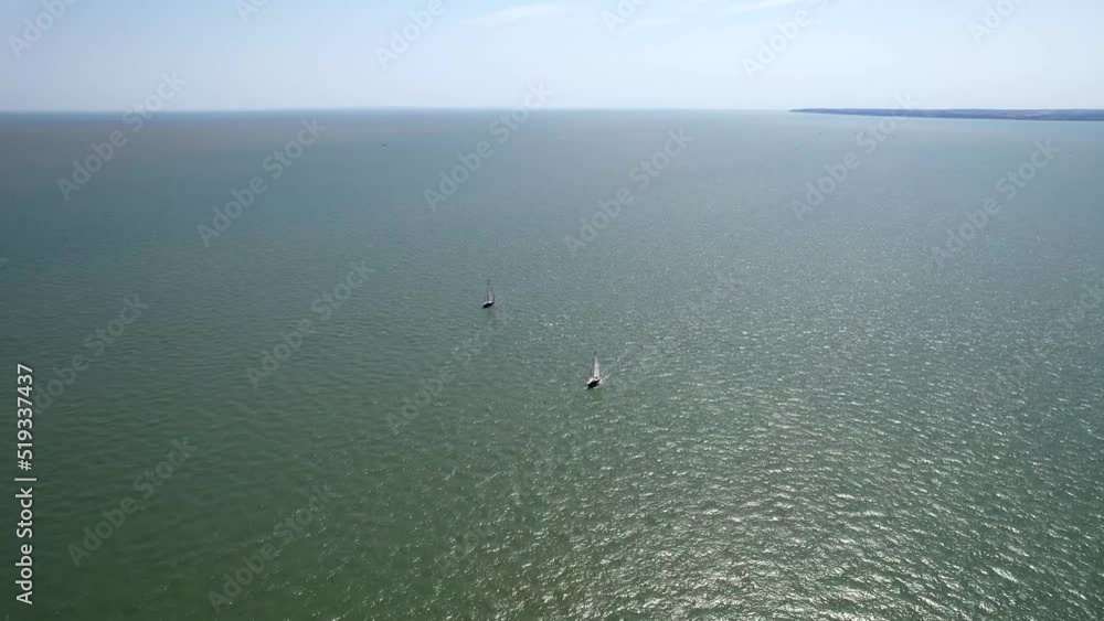 A drone flyover of two sail boats along the English coastline. A drone flyover of two sail boats along the English coastline.