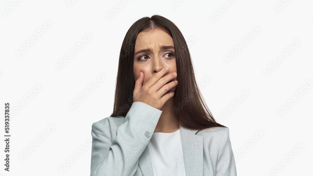 upset businesswoman in grey blazer covering mouth isolated on white. upset businesswoman in grey blazer covering mouth isolated on white.