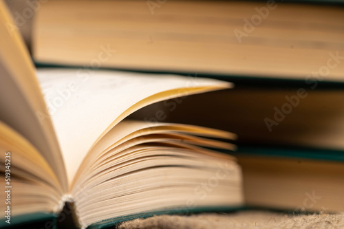 A stack of books and an open book on the table. Close-up  selective focus