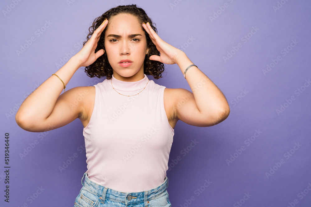 Sick brunette woman suffering from a strong headache Sick brunette woman suffering from a strong headache