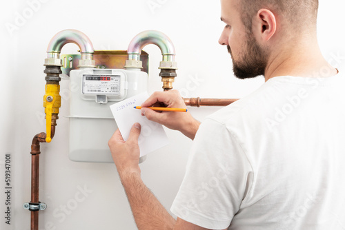 Tapeta Young man reading the gas meter in the private house, counter for distribution domestic gas
