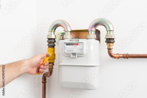 Picture of man opening the gas valve. Gas meter in private house. High costs of gas.
