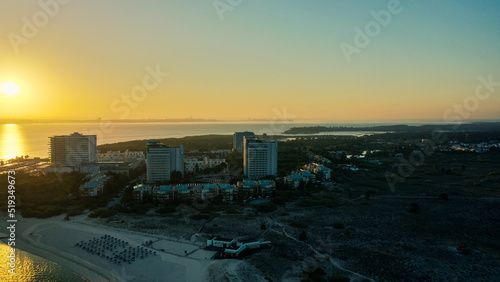 Aerial Bird's eye view of huge sunrise over Troia Peninsula on a sunny day, near Lisbon.