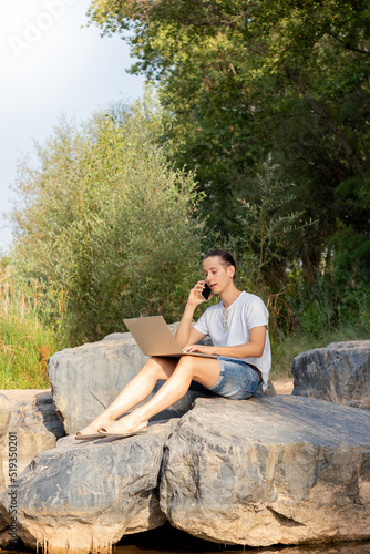 Vertical view of the crude reality of a freelancer male working during his retreat in nature