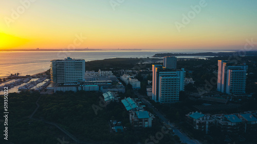Aerial Bird's eye view of Troia Peninsula on a huge sunrise, near Lisbon. Orange and golden sky in the background