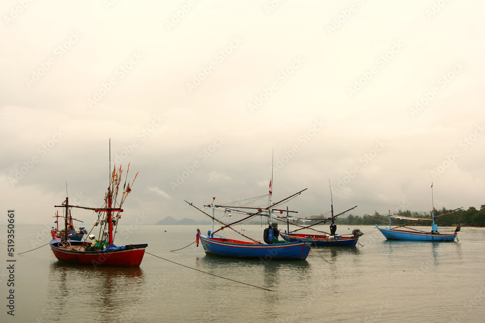 Many fishing boats are moored in the sea from Thailand.  White clouds and sky  with fishing boats scenery.