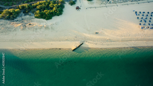 half sandy and half sea with huge sunrise in Beach Troia Rio on Troia Peninsula, Setubal, portugal
