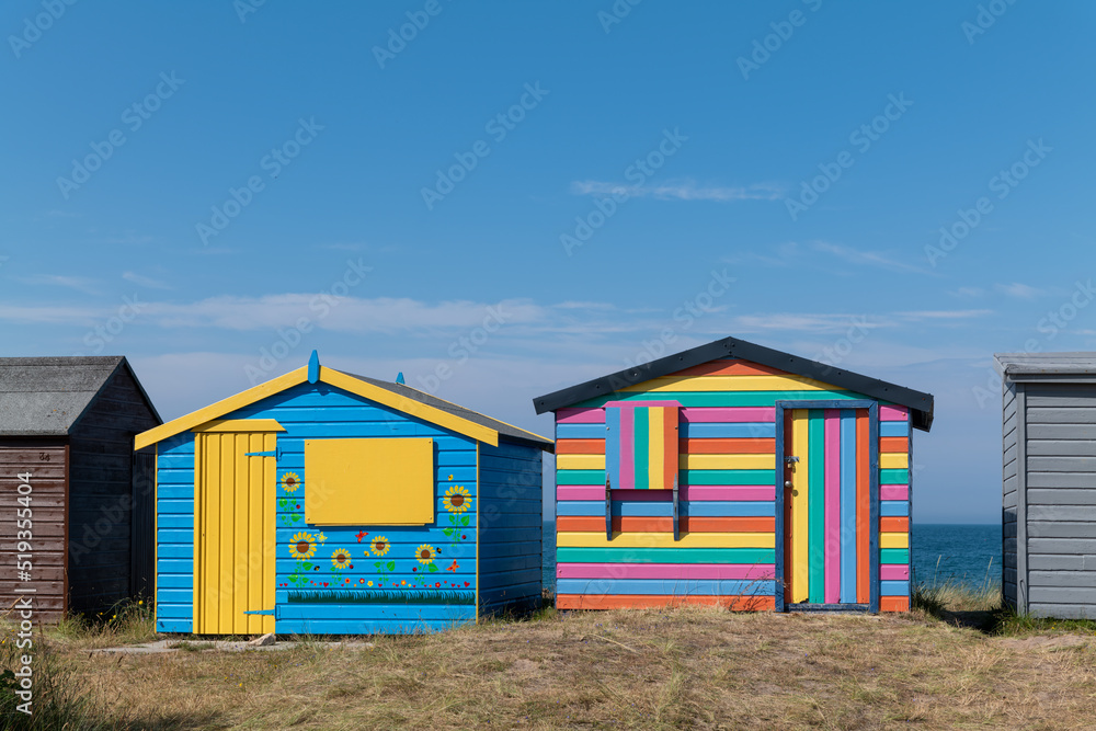 Naklejka premium 18 July 2022. Hopeman, Moray, Scotland. This is the very colourful beach huts at Hopeman, Moray on a very sunny summers day.