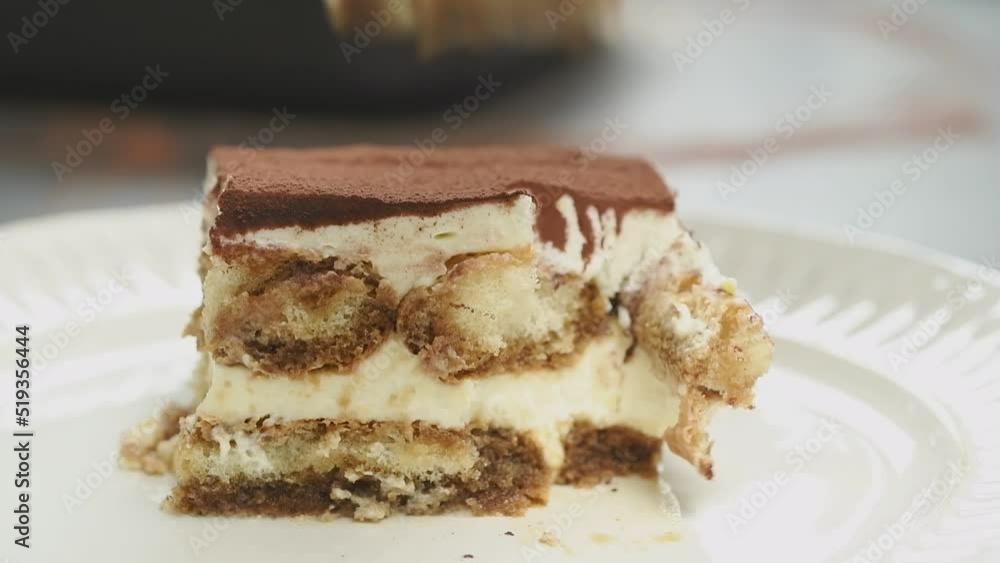 Fork breaks off a piece of tiramisu cake.
Fork breaks off a piece of tiramisu cake.