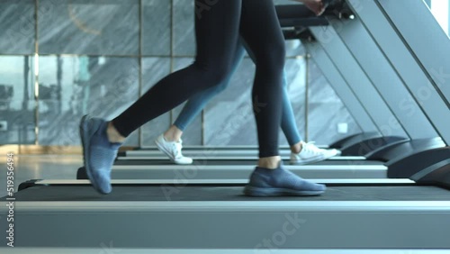 woman exercising on treadmill, Young athletic woman legs jogging on treadmill in hotel sport club slow motion