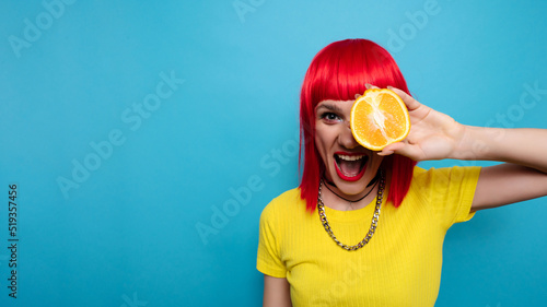 Wallpaper Mural A young beautiful funny model with a slice of orange near her eyes, in the background with makeup, hairstyle. Bright, funny summer photo. Bright background. A place for your text. Torontodigital.ca