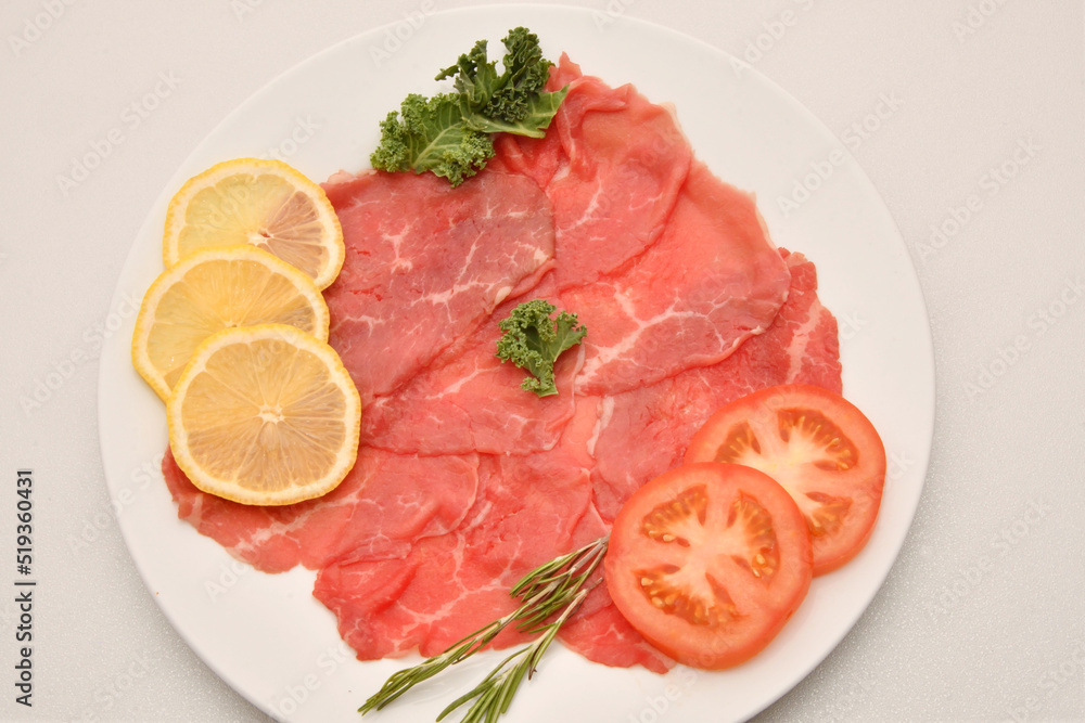 Carpaccio dish of thinly sliced pieces (slices) raw beef tenderloin Carpaccio dish of thinly sliced pieces (slices) raw beef tenderloin