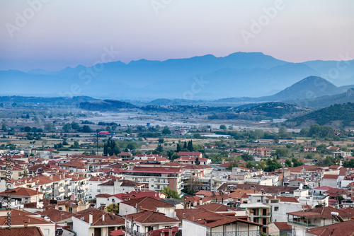 Churches and red roofs of white houses of the Greek city of Kalabaka at sunset, Pindos Mountains, Thessaly, Greece, Europe