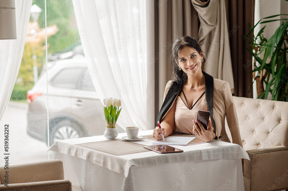 Successful business woman using phone during coffee break in the cafe Successful business woman using phone during coffee break in the cafe