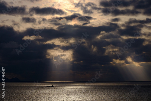 雲間からの朝日に照らされる海面