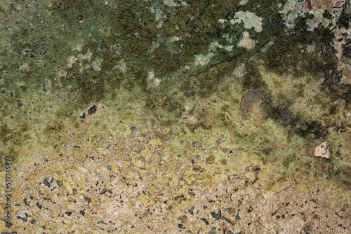 Old cracked concrete with a green tint with traces of copper oxide
