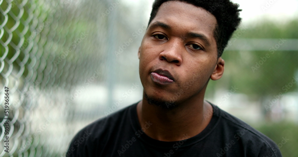 Thoughtful young black man standing outside thinking. Pensive mixed race person Thoughtful young black man standing outside thinking. Pensive mixed race person
