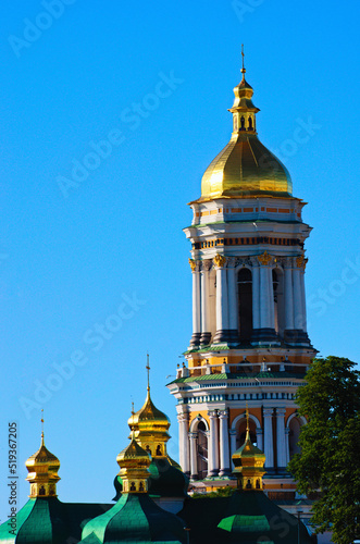 Gold domed Bell tower of Kyiv Pechersk Lavra. Blue sky background. Orthodox Christian monastery. UNESCO World Heritage Site. Scenic morning view