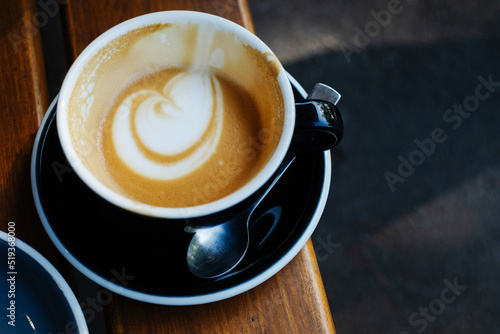 Overhead view of half empty coffee latte in black mug