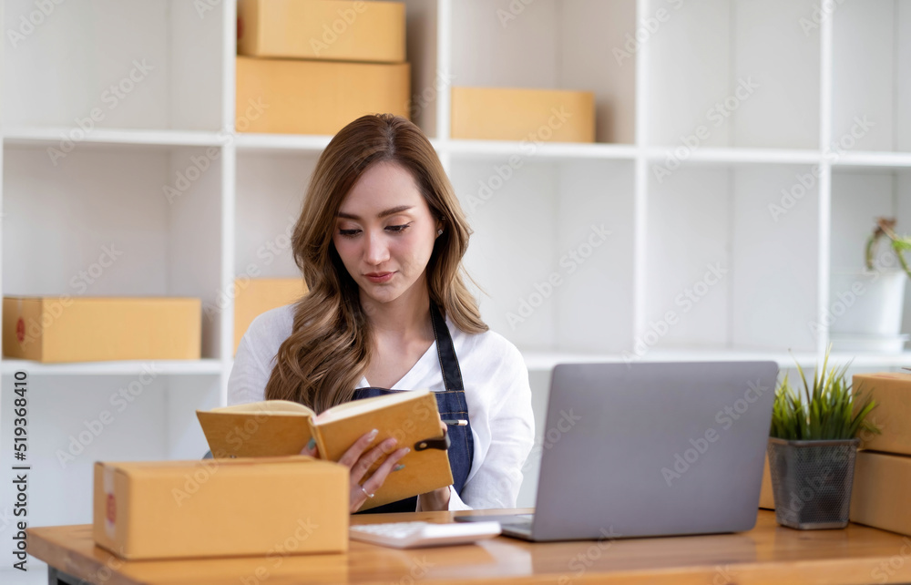 Portrait of Asian young woman SME working with a box at home the workplace.start-up small business owner, small business entrepreneur SME or freelance business online and delivery concept. Portrait of Asian young woman SME working with a box at home the workplace.start-up small business owner, small business entrepreneur SME or freelance business online and delivery concept.