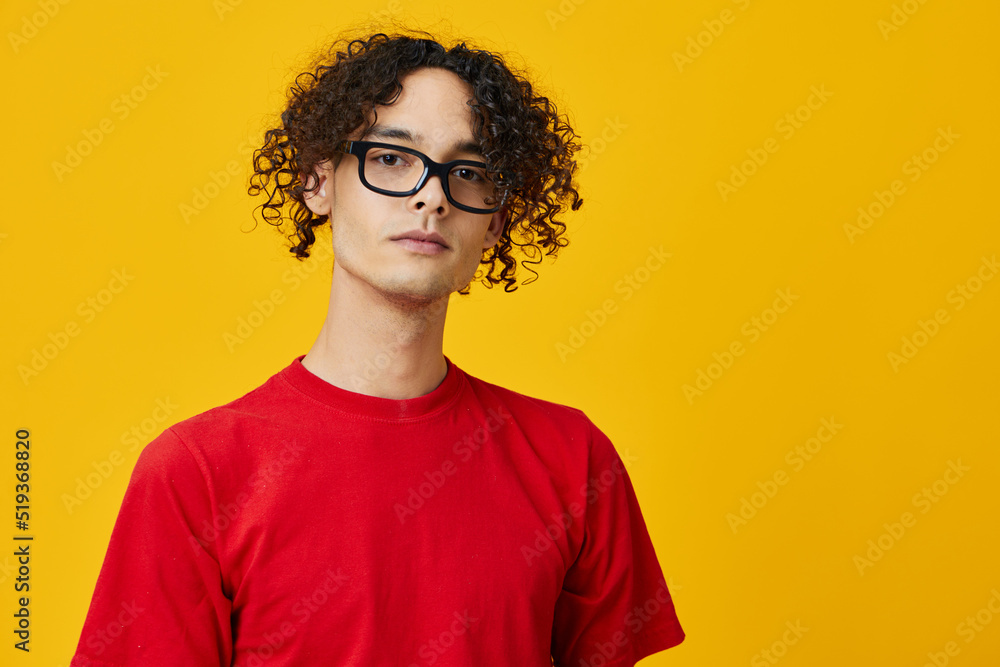 Lovely myopic young student man in red t-shirt funny eyewear looks at camera posing isolated on over yellow studio background. The best offer with free place for advertising. Education College concept Lovely myopic young student man in red t-shirt funny eyewear looks at camera posing isolated on over yellow studio background. The best offer with free place for advertising. Education College concept
