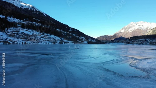 Eisseglen auf dem Haidersee in Südtirol im Vinschgau. Drohne hinter einem Eissegler. Gefrorener See 2 photo