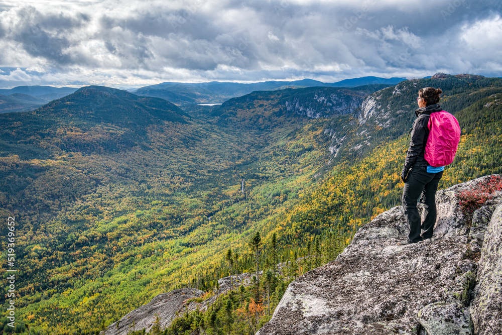 A lone woman hiking Morios mountain on a cloudy Fall day, Charlevoix, QC, Canada