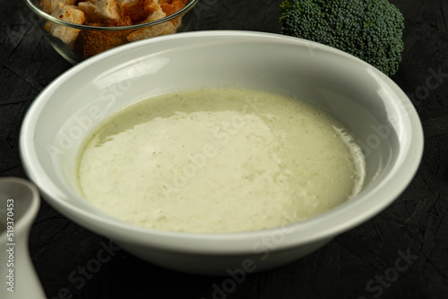 broccoli cream soup in white bowl on black desk