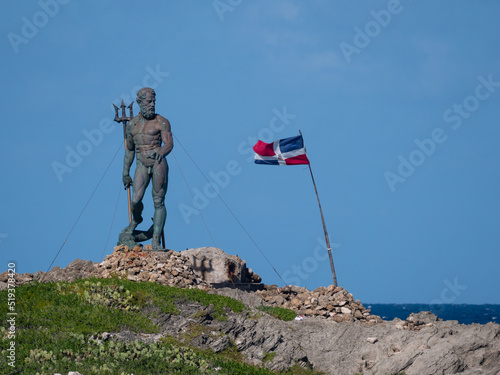 Neptune statue with flag on the rock in puerto plata dominican republic photo
