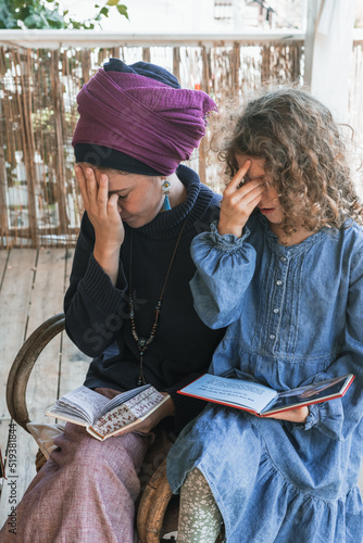 Canvastavla Young religious jewish woman with a headscarf on her head prays with siddur on her knees