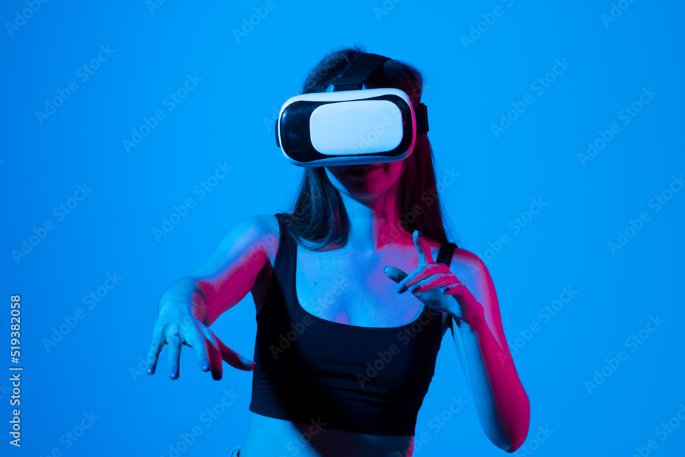 Young brunette woman wearing VR headset looking at art objects while visiting modern exhibition using augmented reality technology. Future technology concept. Young brunette woman wearing VR headset looking at art objects while visiting modern exhibition using augmented reality technology. Future technology concept.
