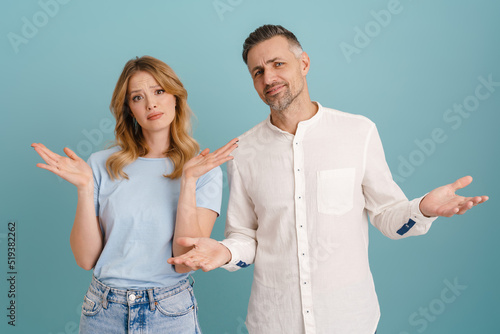 White displeased couple frowning while gesturing at camera