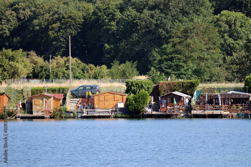 Pier on the shore of the pond with fishing houses for equipment Pier on the shore of the pond with fishing houses for equipment