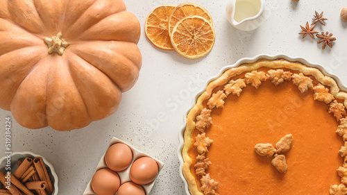 Thanksgiving Day American Pumpkin Pie with ingredients for baking on white background. View from above. Flat lay.