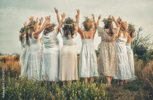 Photos Women in flower wreath on sunny meadow, Floral crown, symbol of summer solstice